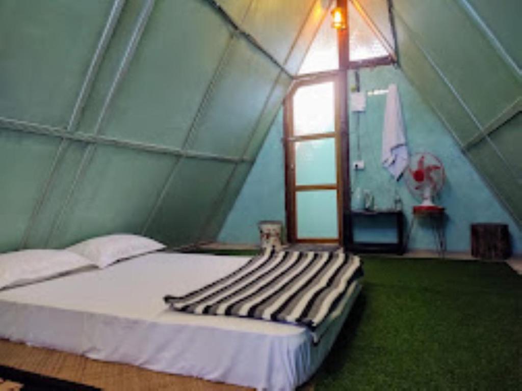 帕西加特Nature's Hub Homestay Pasighat的帐篷内带床的房间,设有窗户