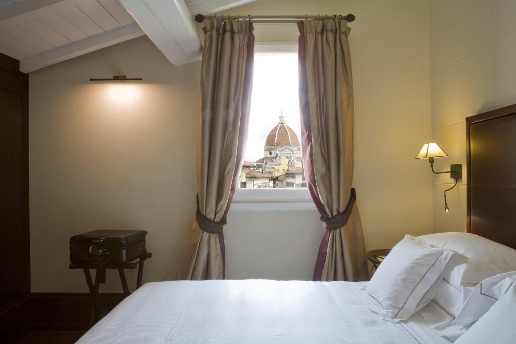 佛罗伦萨Hotel L'Orologio - WTB Hotels的卧室配有白色的床和窗户。