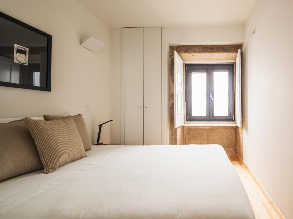 波尔图InSitu Trindade by Guestify的卧室配有一张大白色床和窗户