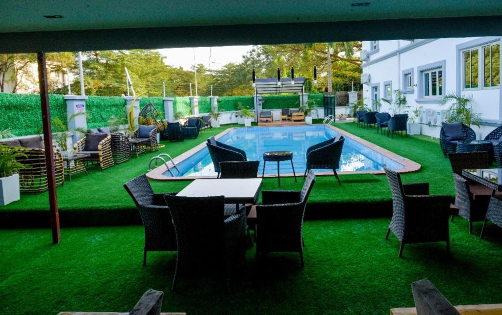 阿布贾SS3 Jabi Hotel的一个带桌椅的庭院和一个游泳池