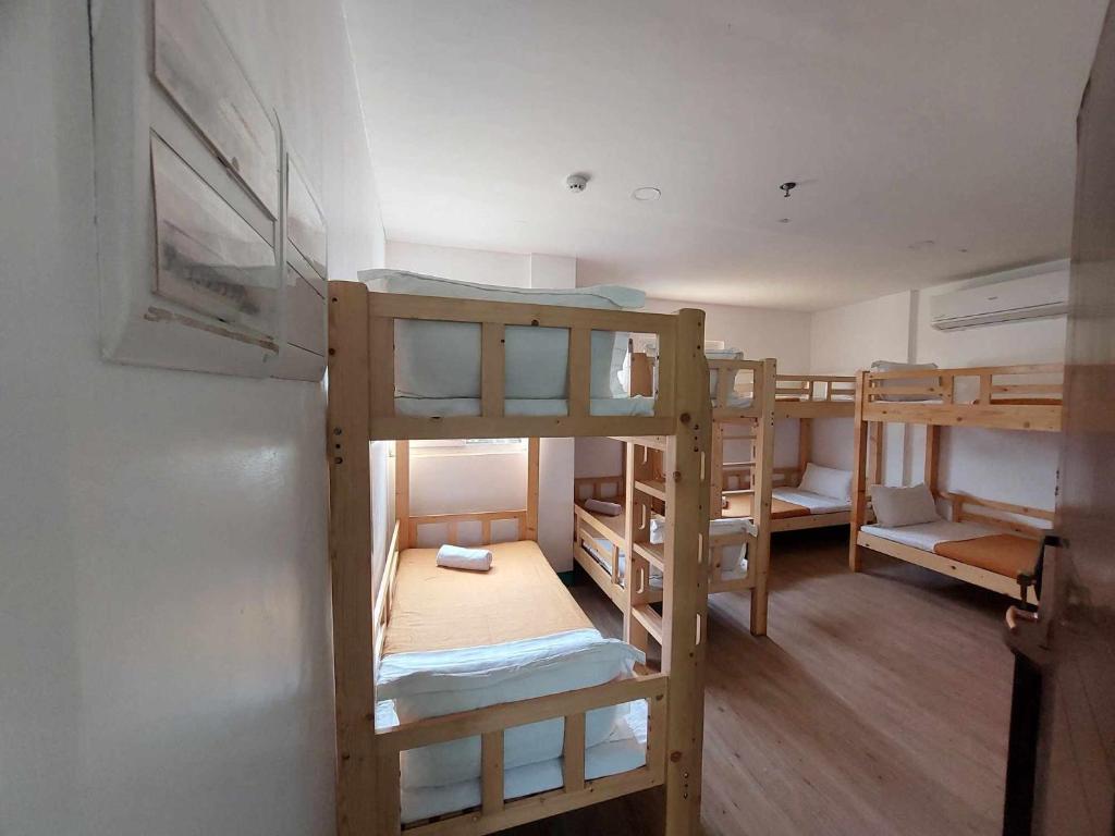 长滩岛Emerald Bay Boracay的客房设有三张双层床和一台冰箱。