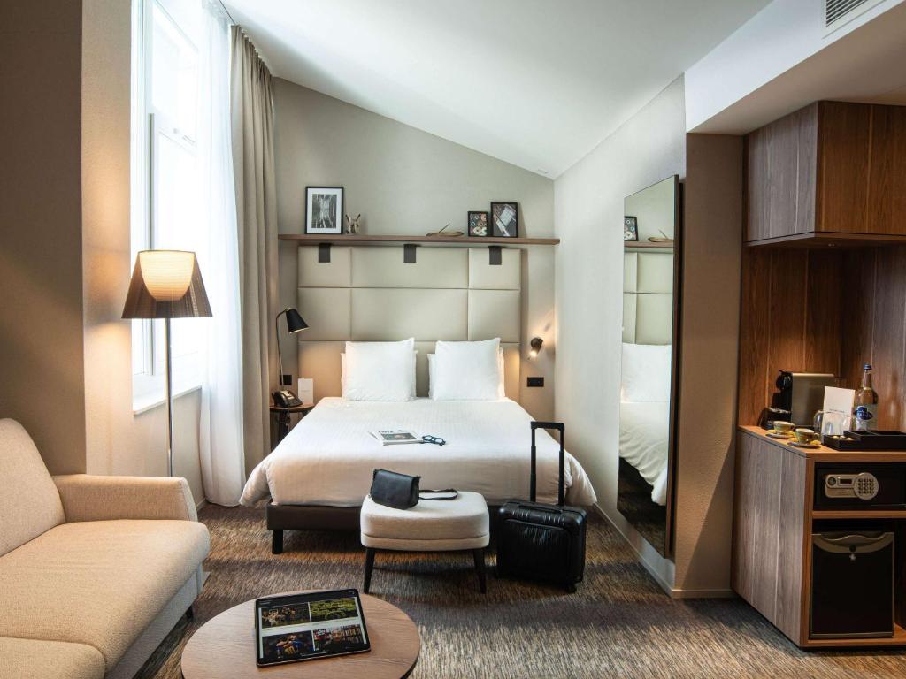 弗里堡Mercure Fribourg Centre Remparts的酒店客房,配有床和沙发