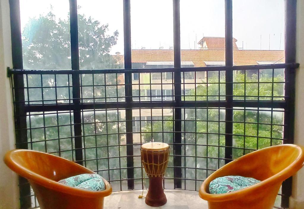 迈索尔Funky Buddha Hostel的两把橙色椅子坐在窗前