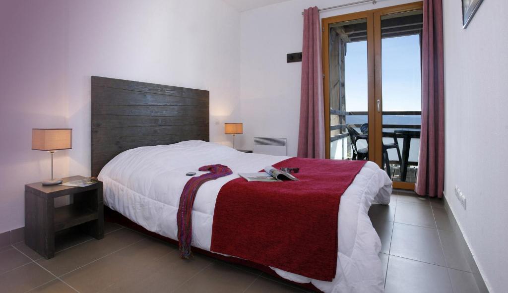 丰罗穆勒匹克德劳斯公寓酒店的一间卧室配有一张带红色毯子的大床
