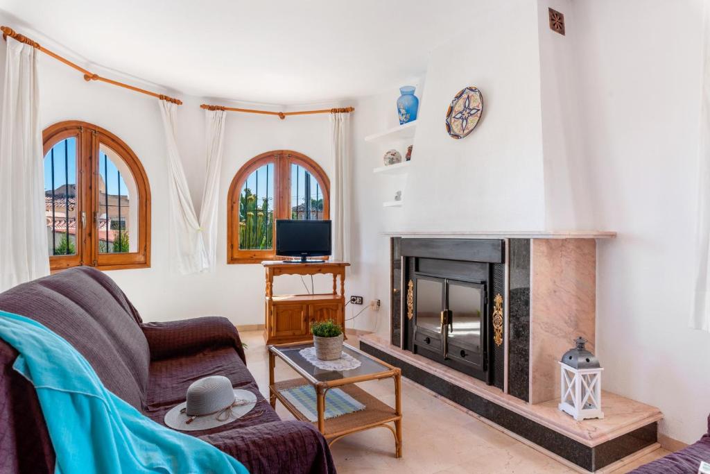 卡尔佩Villa Cruz - PlusHolidays的客厅设有壁炉和沙发。