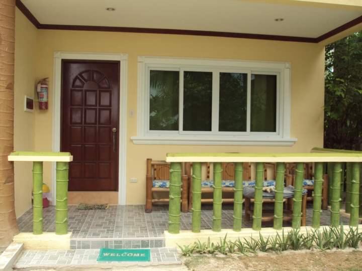 罗昂HMC Guesthouse - Malapascua Island Air-conditioned Room #2的前廊和门的房子