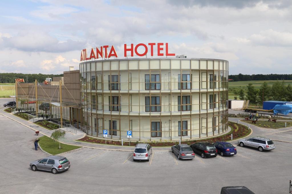 Stare JeżewoHotel Atlanta的停车场内有车辆的旅馆