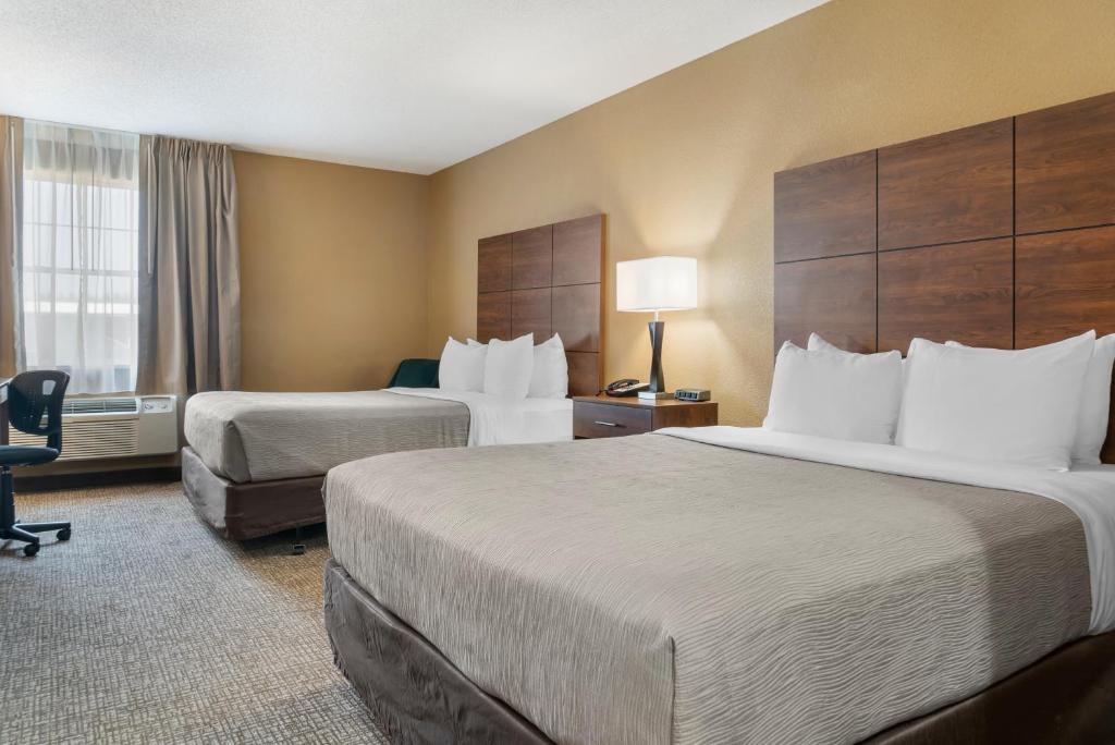 马尼斯蒂克Quality Inn & Suites的酒店客房配有两张床和一张书桌