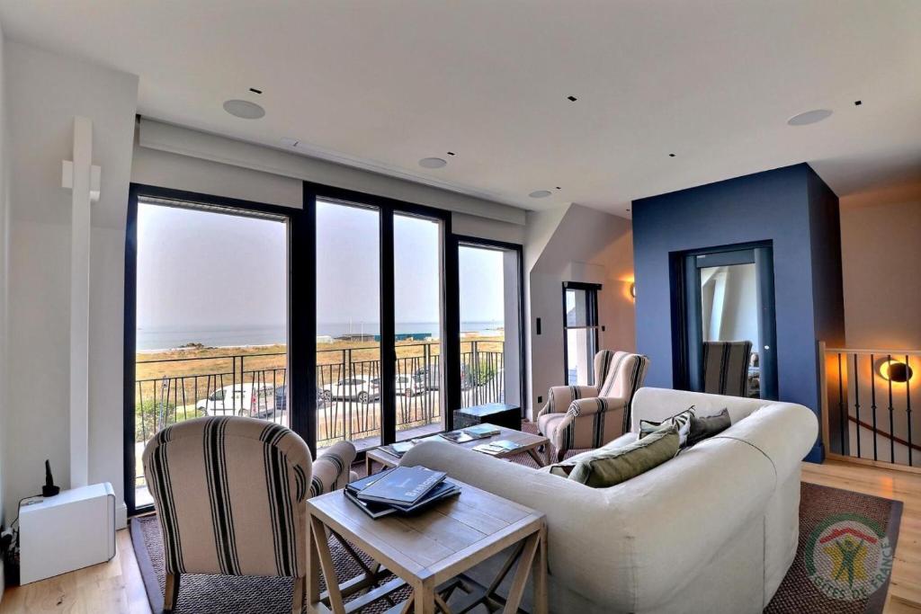 圣吕奈尔Les dunes的带沙发和椅子的客厅以及阳台。