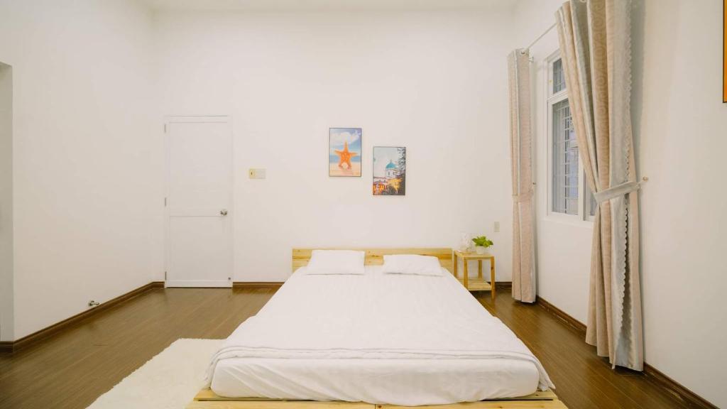 芽庄Nha Trang Riverside Villa的白色客房的两张床,设有窗户