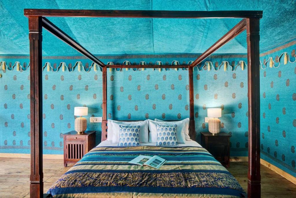 布什格尔Foothill Pushkar Resort的一间卧室配有一张天蓬床和蓝色的墙壁