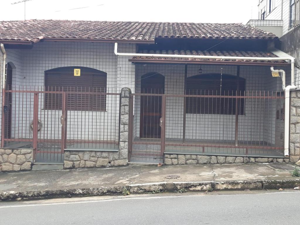 维索萨Quartos em casa no Clelia Bernardes的一座带两扇门和栅栏的建筑