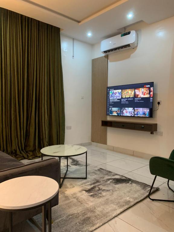 伊巴丹Luxury apartments的客厅配有2张桌子和平面电视