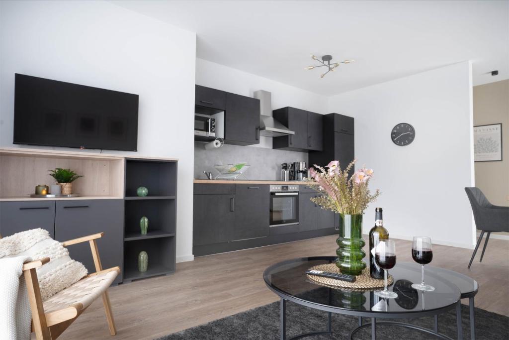 奥斯纳布吕克Schicke Apartments in Osnabrück I private Parkplätze I home2share的一间带桌子的客厅和一间厨房