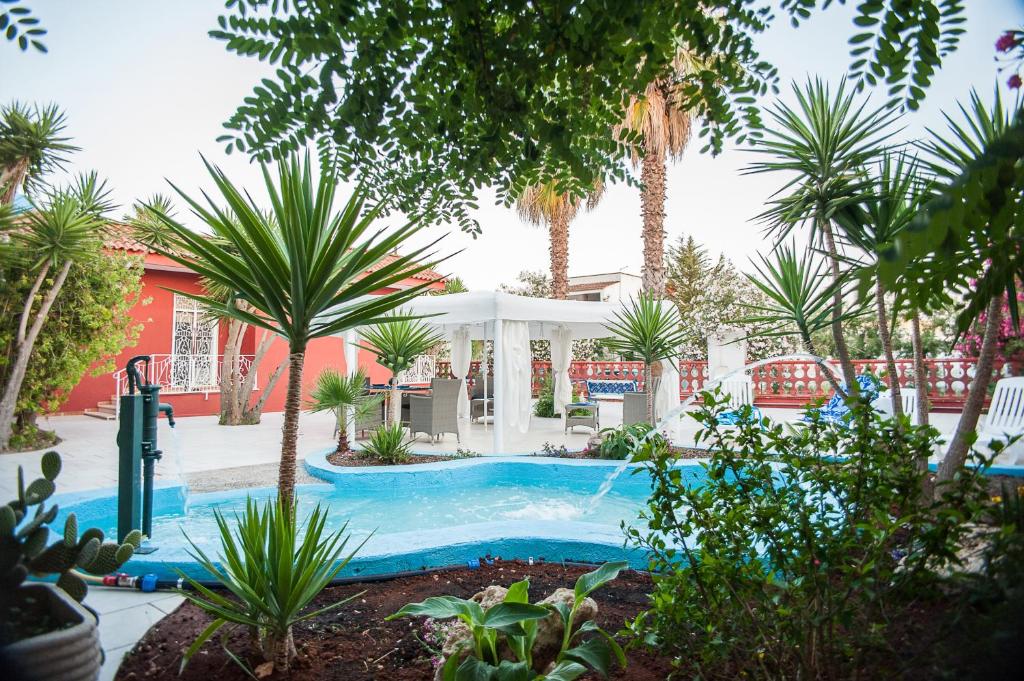 普罗斯西托角Villa Gisella的棕榈树庭院内的游泳池