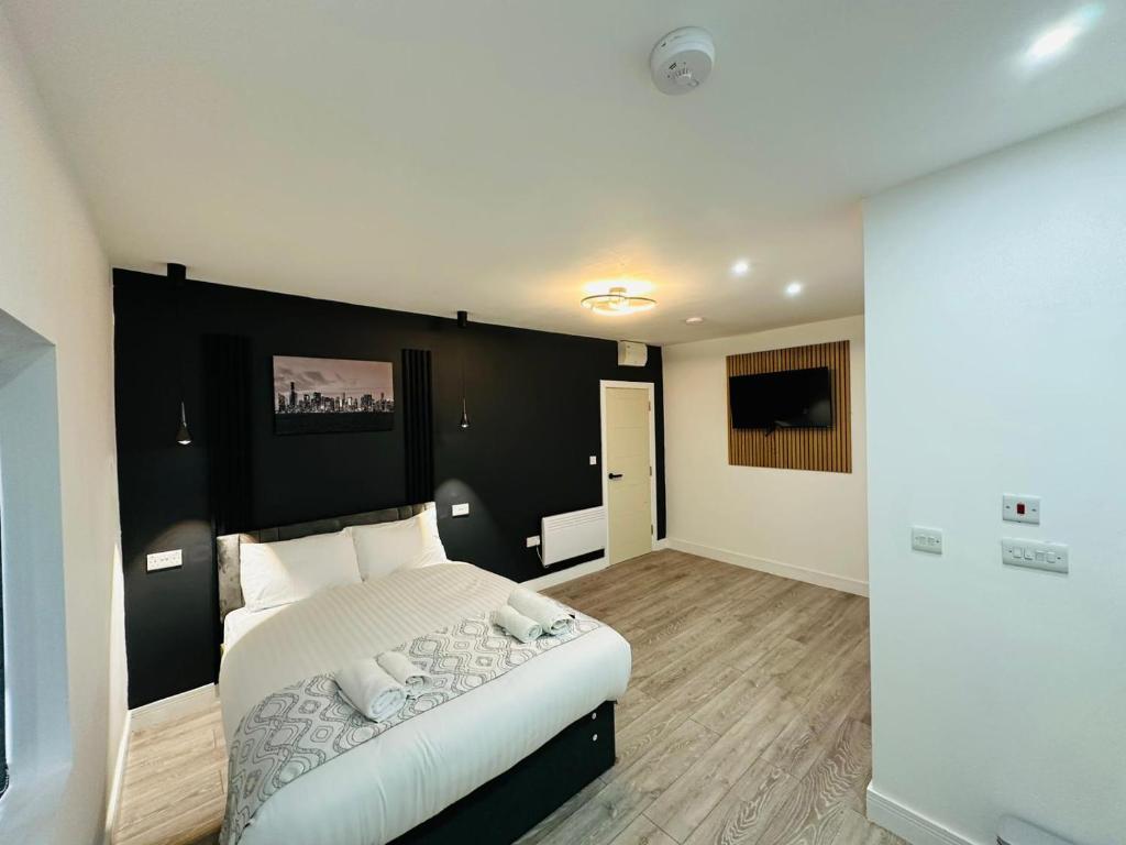 海斯SK Heathrow Hotel的一间卧室配有一张白色大床和黑色床头板