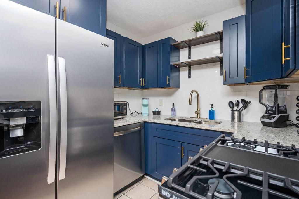 斯内尔维尔Luxurious Extended Stay Dream~3 Kings~Desks~TV's的厨房配有蓝色橱柜和不锈钢冰箱
