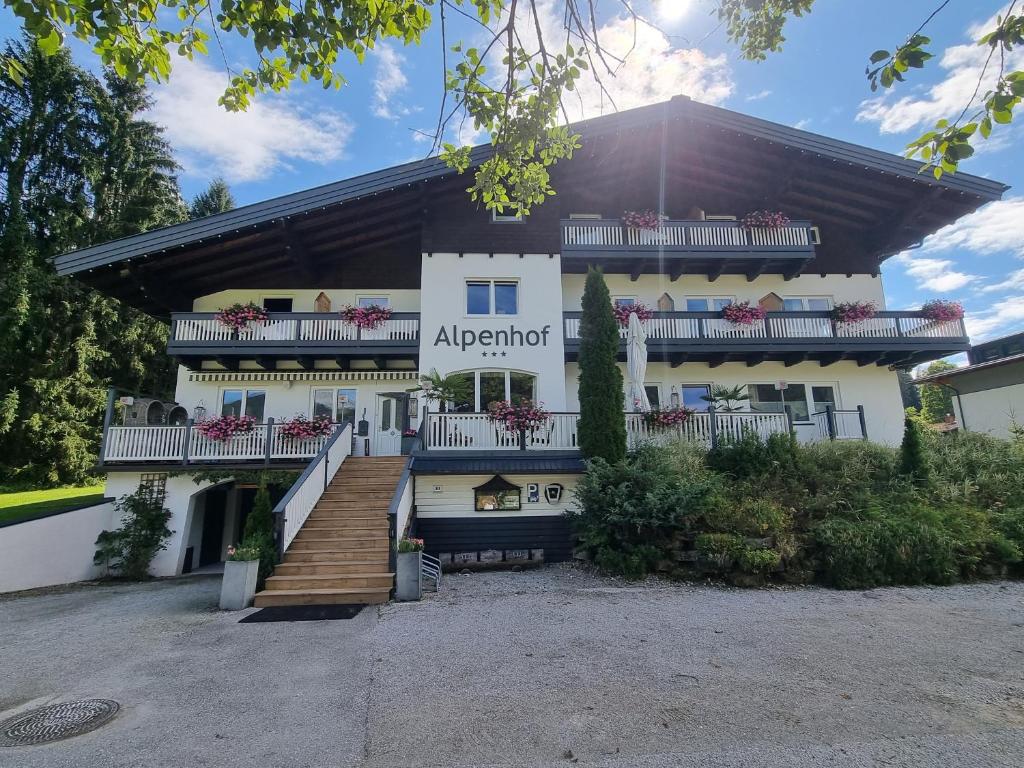 滕嫩山麓圣马丁Boutique Hotel Alpenhof的一座白色的大建筑,设有楼梯和阳台