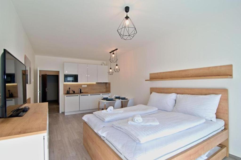 伏尔塔瓦河畔利普诺Apartment KORZO 318/3的一间带白色大床的卧室和一间厨房