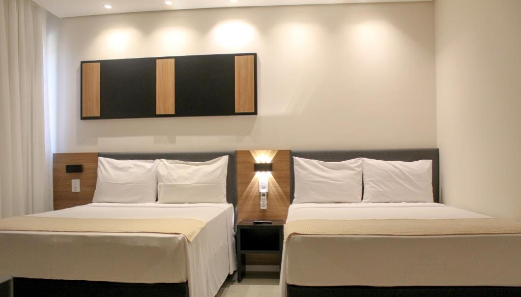 AndradasPorto das Asas Park Hotel的酒店客房,设有两张床和一盏灯