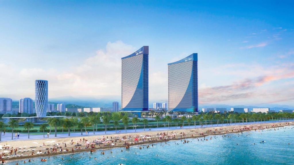 巴统Panorama Orbi Luxury Towers的一群人与海滩上的建筑