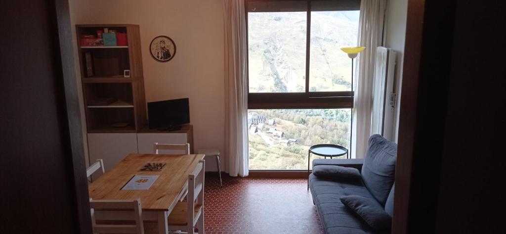 圣拉里苏朗Appartement St Lary Soulan pied des pistes (le Pla d’Adet) 5 personnes的带沙发、桌子和窗户的客厅