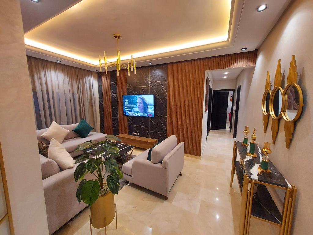 卡萨布兰卡modern apartment opposite the Hassan2 mosque, very well equipped and stylish, 85 m² with gym and direct sea view with underground garage. (couple of Arab origin without marriage certificate will be refused)的带沙发和电视的客厅