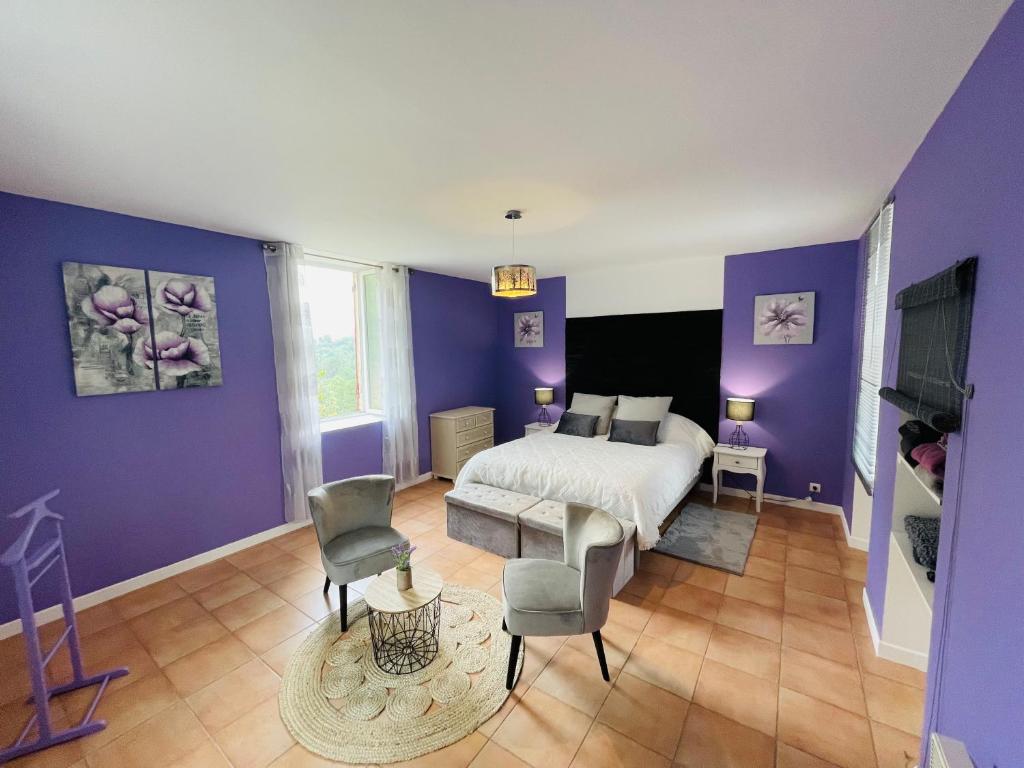 圣让迪加尔Chambre d'hôte Lavande - Le soleil des Cévennes的一间卧室设有紫色的墙壁和一张床及椅子