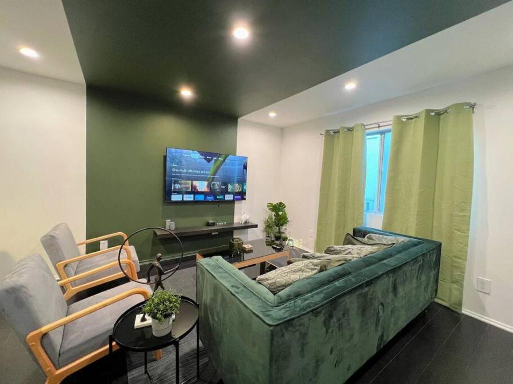 洛杉矶2BR Suite in the Heart of Hollywood -BR5的客厅配有绿色沙发和电视