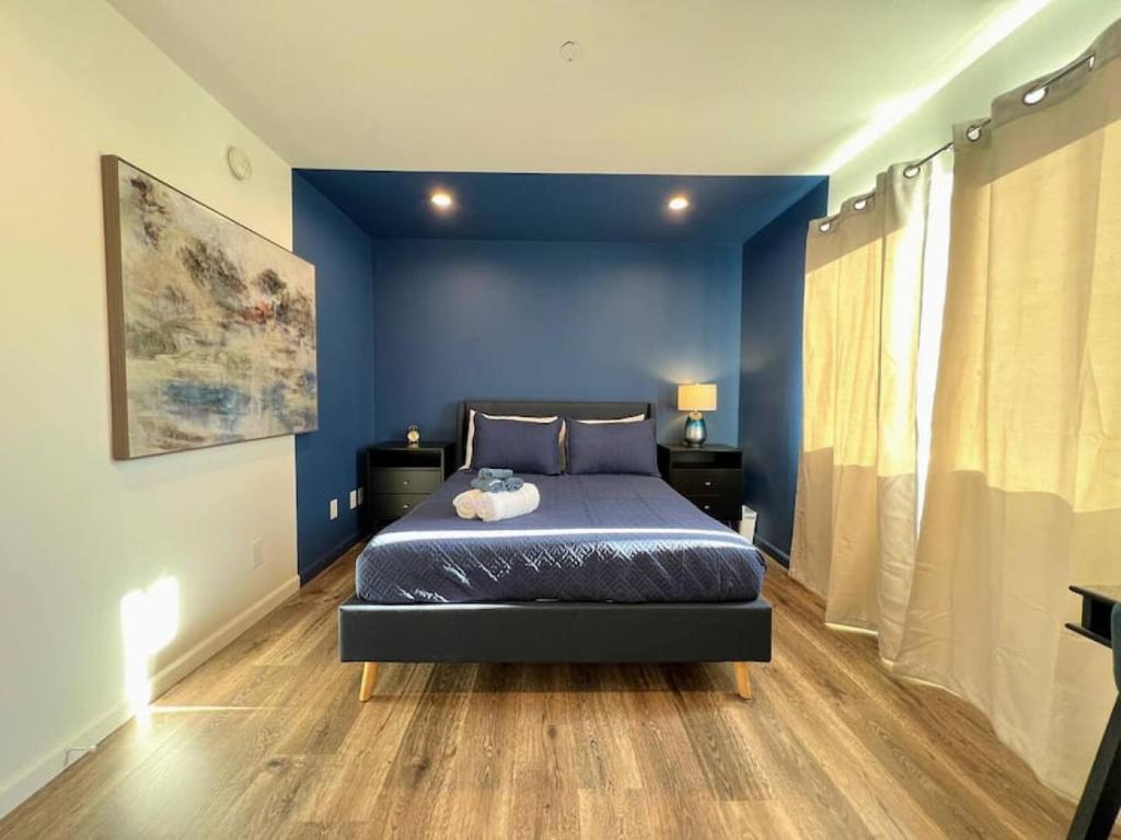 洛杉矶Trendy 2BR Near Hollywood Hotspots - BR9的一间卧室配有一张蓝色墙壁和木地板。