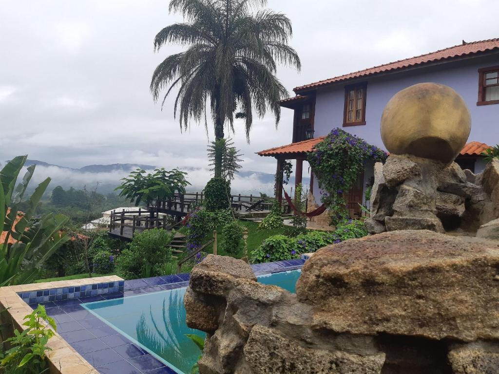 蒂拉登特斯Pousada Residência Balestra的一个带游泳池和房子的度假胜地