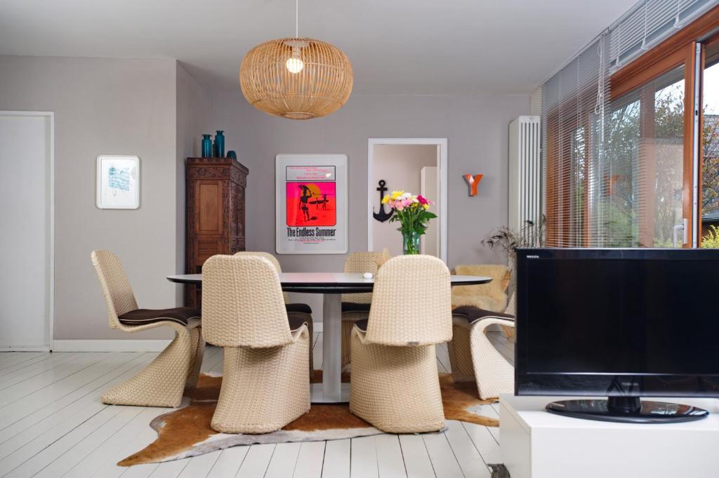 韦斯特兰Captain's Lounge - Bungalow XL的一间带桌椅和电视的用餐室