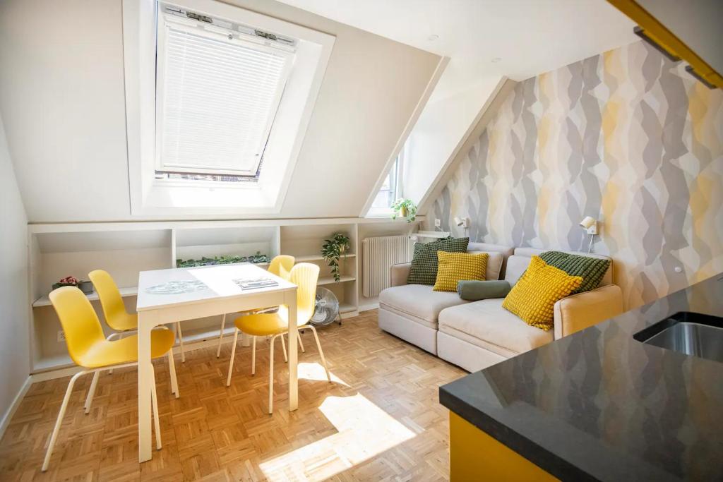 伯尔尼bedinBERN Aparthotel的厨房以及带桌子和黄色椅子的客厅。