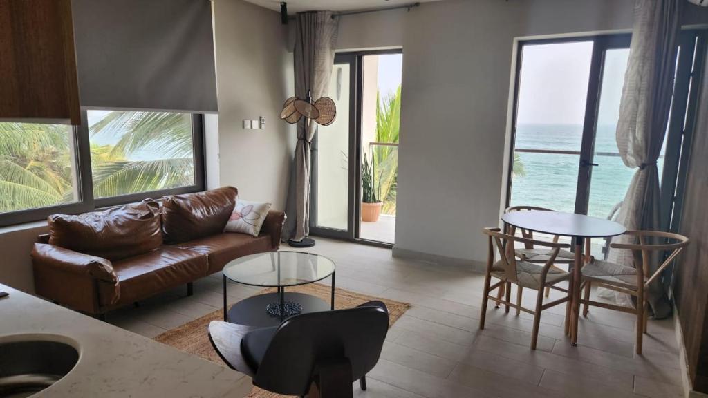 KokrobiteSerenity Terraces Beach, Hotel - Kokrobite的客厅设有一张沙发和桌子,享有海景。