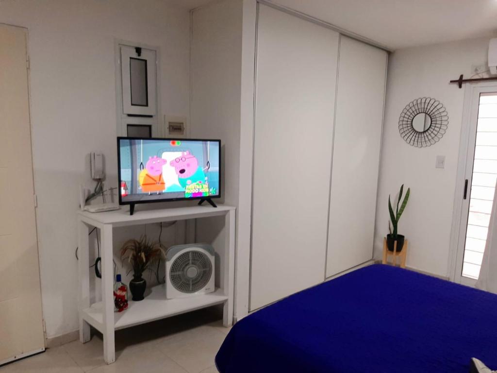 圣米格尔·德·图库玛Hermoso departamento céntrico!的一间客厅,在白色的架子上配有电视