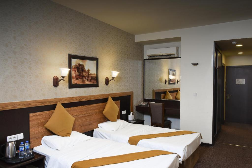 埃尔比勒埃森纳帕酒店的酒店客房配有两张床和一张书桌
