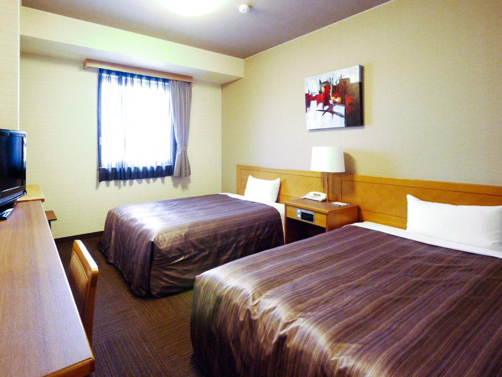 多治见市多治见路线酒店的酒店客房设有两张床和电视。