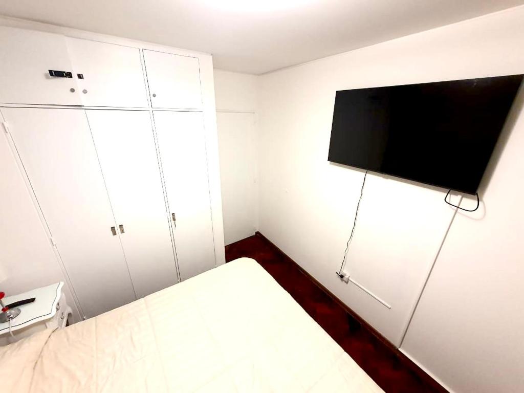 门多萨Hermoso, amplio y nuevo departamento, en la mejor ubicacion de la ciudad de Mendoza的小房间设有一张床和一台平面电视