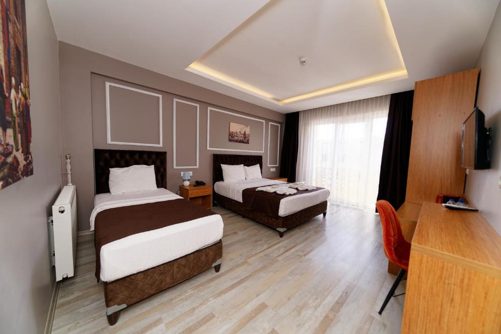 伊斯坦布尔HanPoint Boutique Hotel的酒店客房设有两张床和电视。
