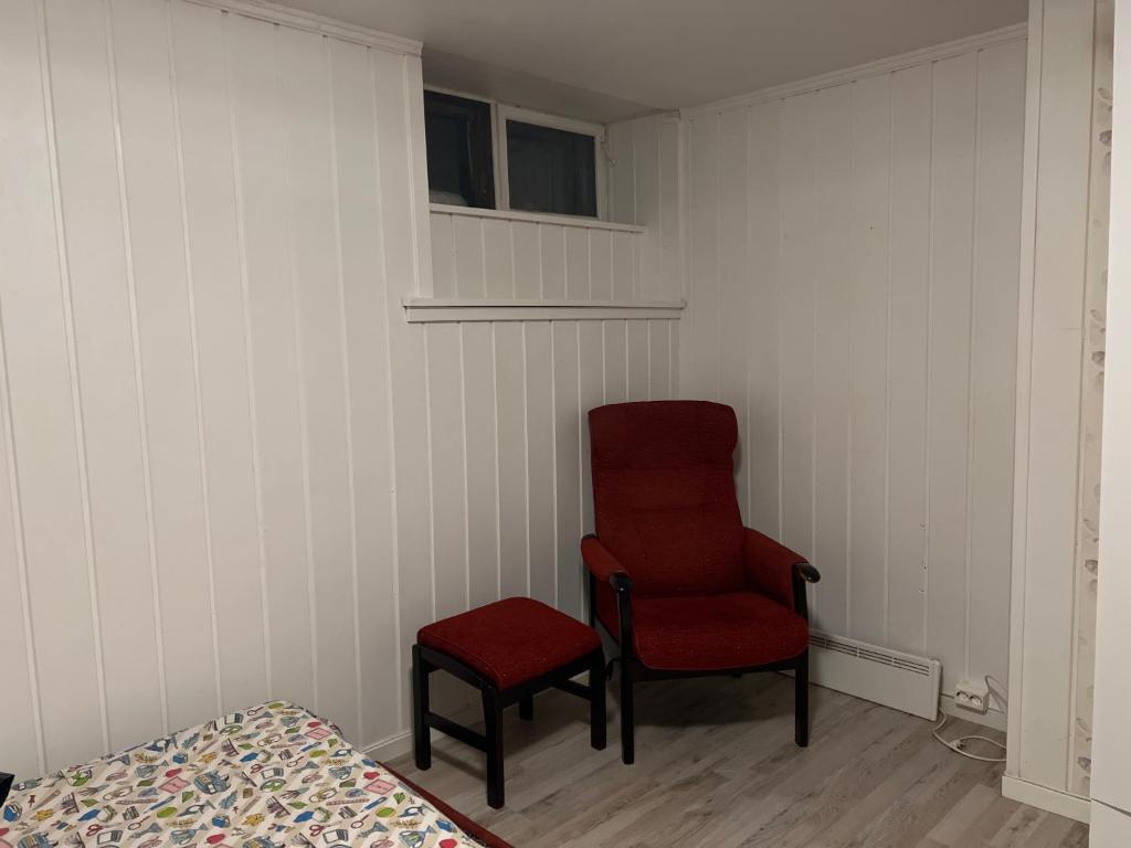 桑讷菲尤尔Råstadveien 20的一间带椅子、红色椅子和床的房间