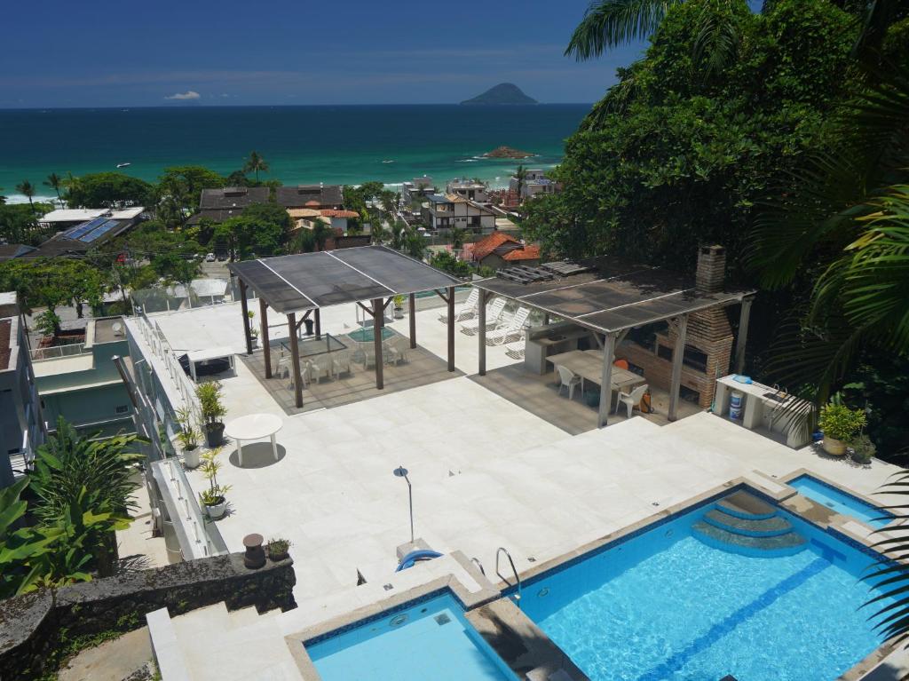 朱奎Suites em Juquei的享有游泳池和大海的顶部景致