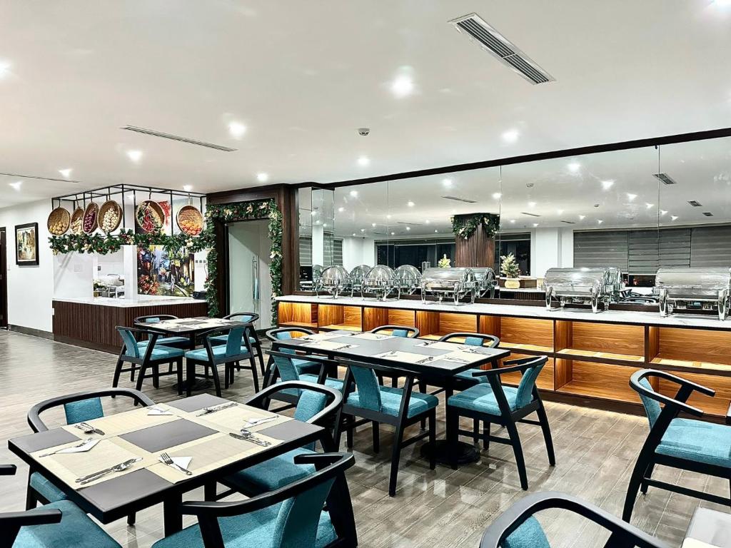 岘港ViAn Hotel And Spa Danang的一间带桌椅的餐厅和一间厨房