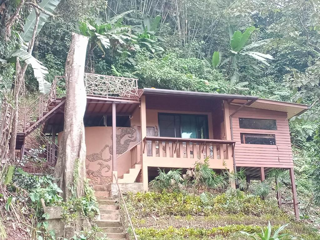 PhatoEco-Logic, Resort for Charity的森林中带阳台的小房子