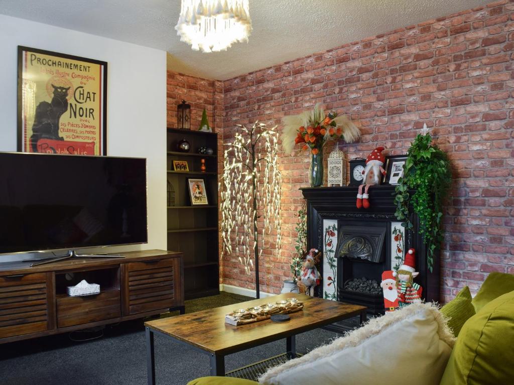 绍斯波特The Hideaway的一间带电视和砖墙的客厅