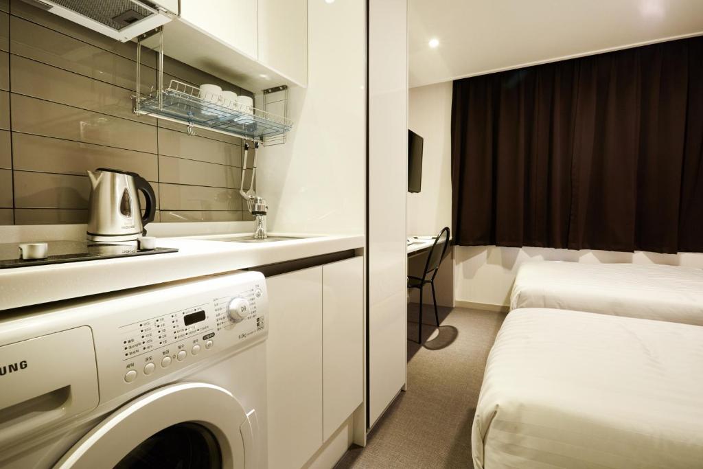 首尔Top Hotel & Residence的客房内的洗衣机浴室