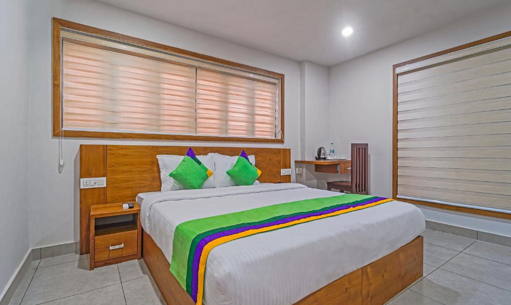 卡尔佩特塔Treebo Trend Regalia Inn Civil Station的一间卧室设有一张大床和一个窗户。