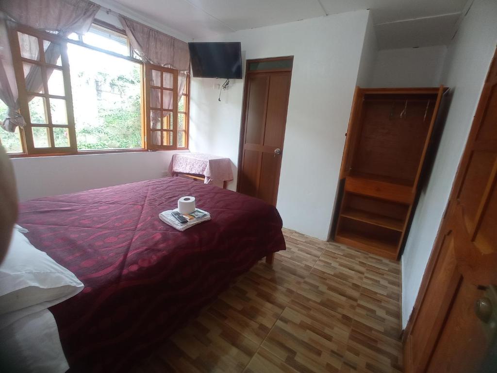 奥克萨潘帕Hospedaje Pinky Lodge的卧室配有一张床,并备有一个托盘,上面装有杯子