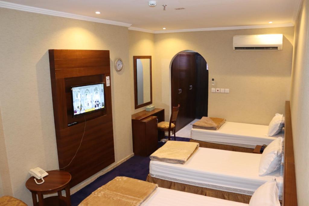 麦加فندق ضيوف المقام للغرف والشقق المفروشة的酒店客房设有三张床和电视。