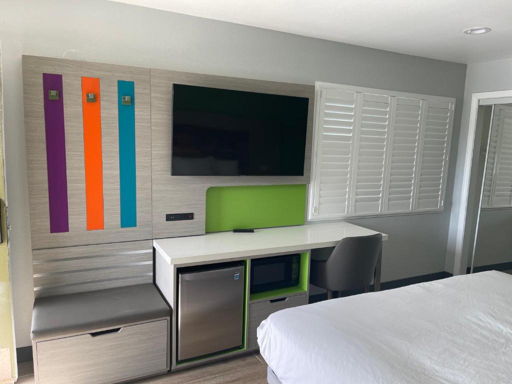 安纳海姆Travel Inn Motel的一间卧室配有一张床、一张书桌和一台电视。