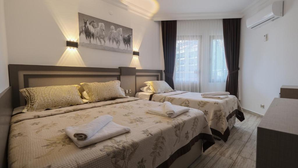 阿拉尼亚蒙特卡洛酒店的酒店客房,配有两张带毛巾的床